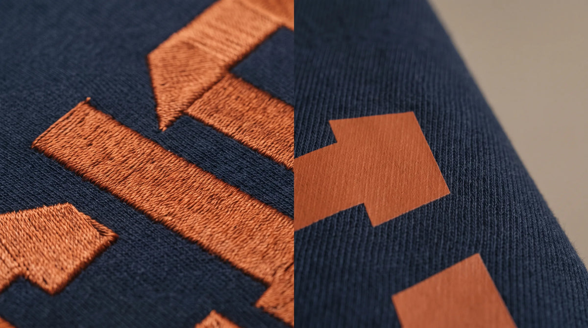 Embroidered stitches next to a DTF print on a navy garment, close up