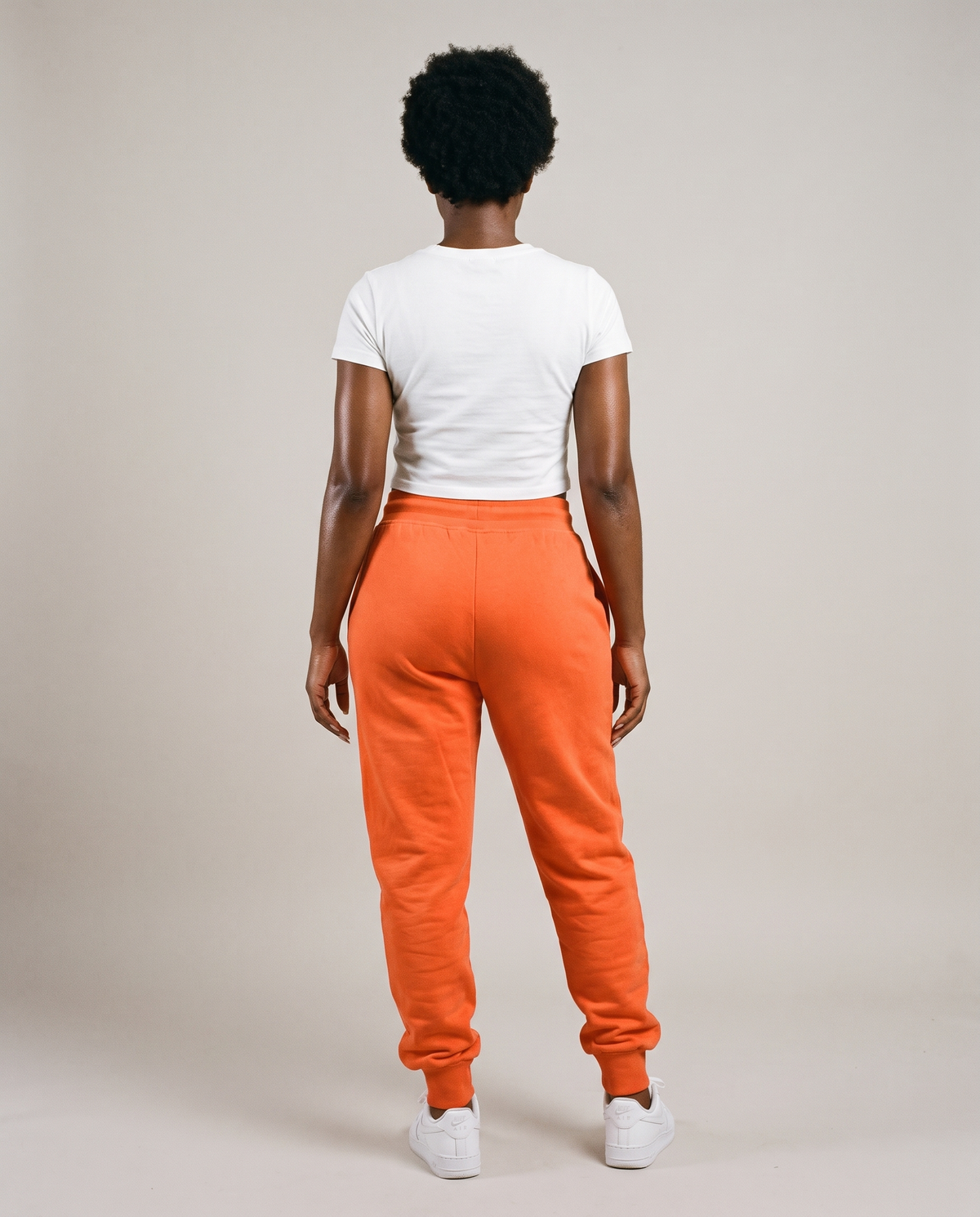 Hopper orange fleece track pants worn by a model, back view