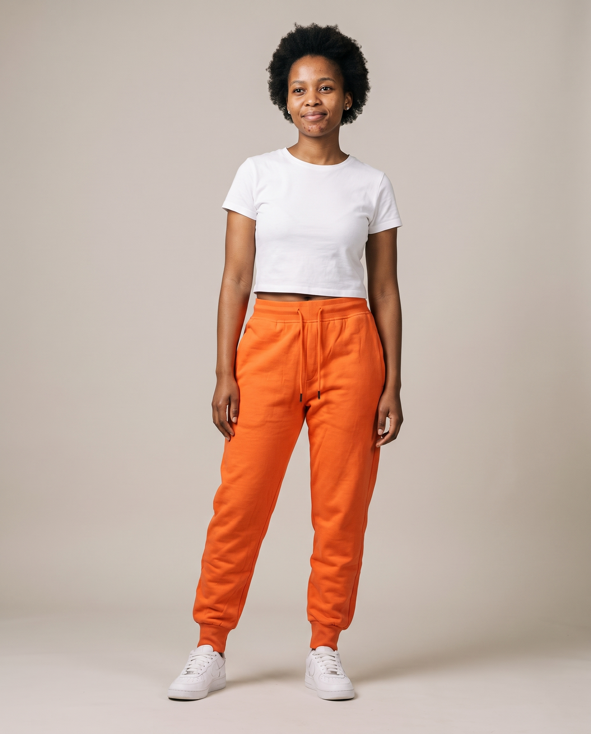 Hopper orange fleece track pants worn by a model, front view
